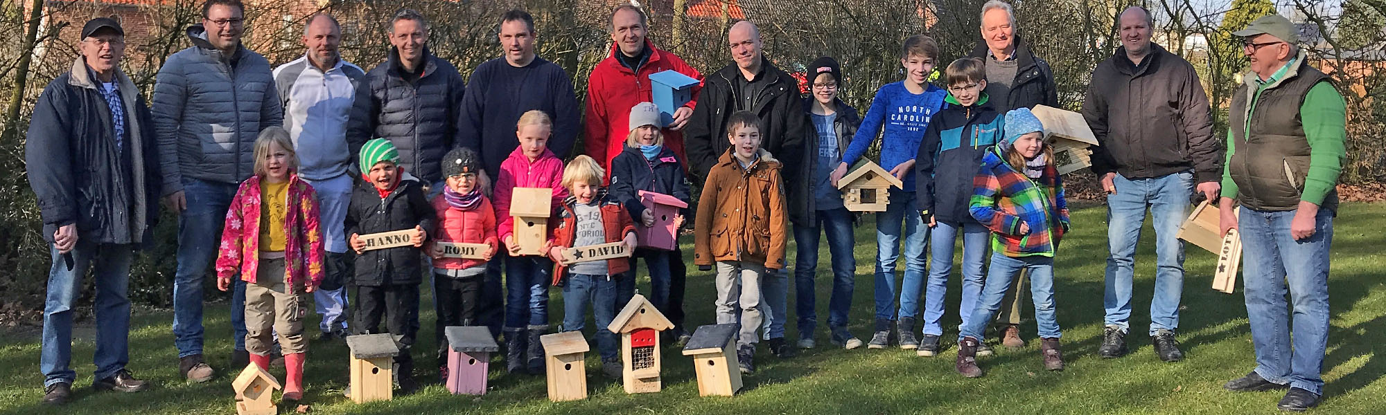 Kinder und Väter bauen Nistkästen