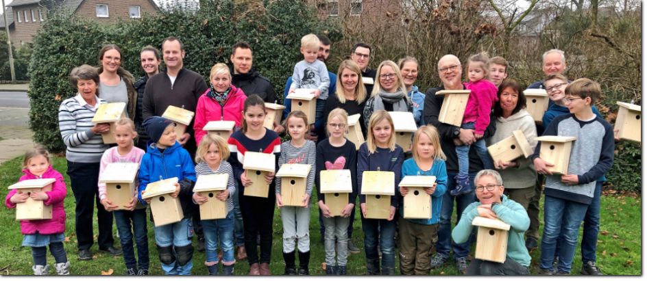 Kinder mit Eltern beim Nisthilfenbau